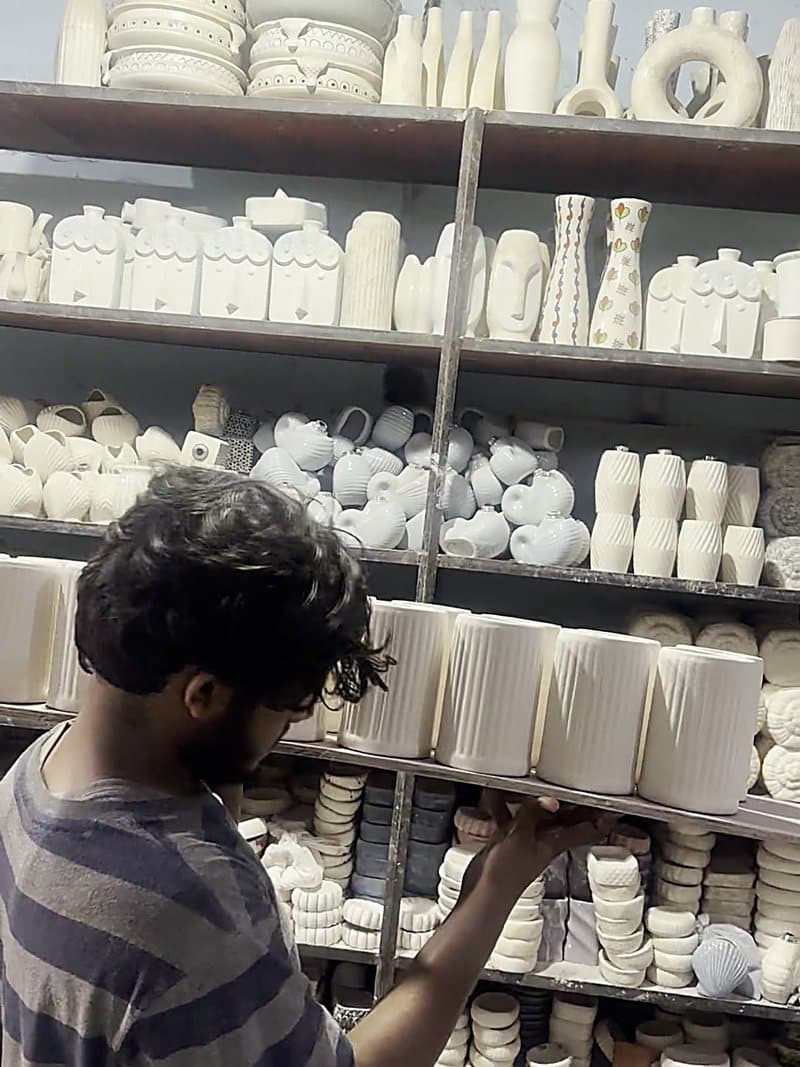 Finished ceramic pieces being handled and checked on the racks