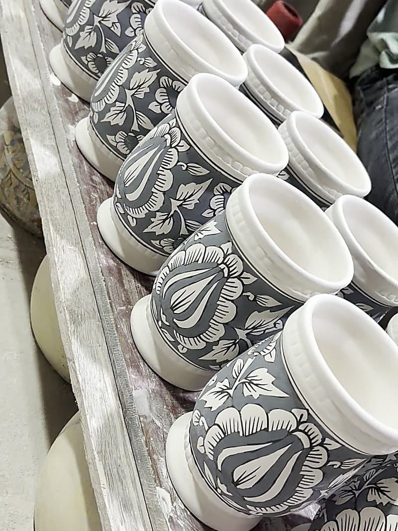 Stacked ceramic jars with hand-painted patterns, finished and sorted